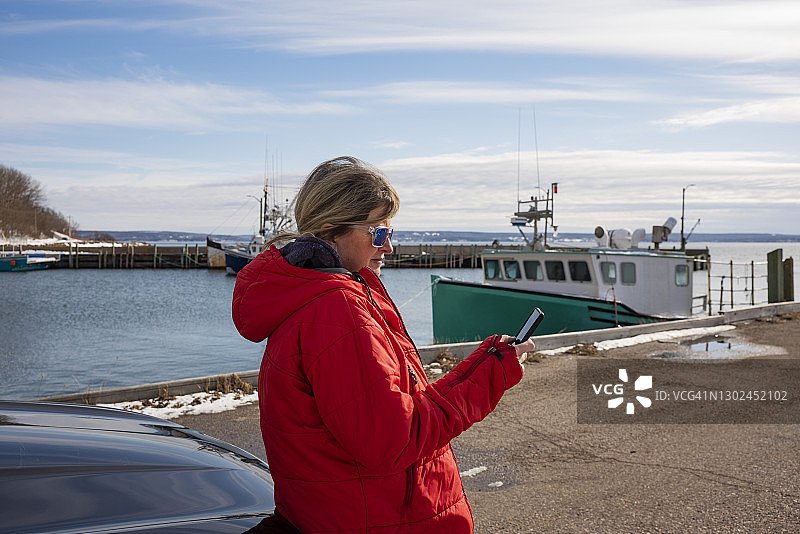 在商业渔港使用手机的女人图片素材