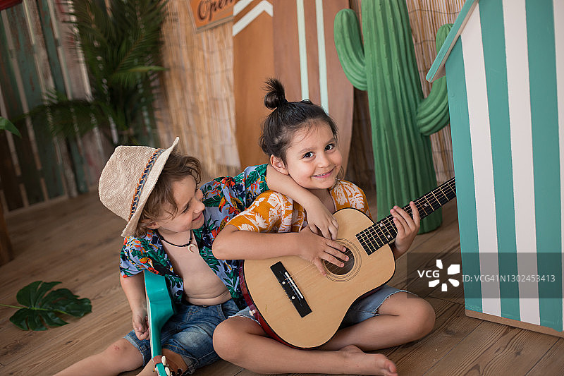 男孩们在海滩风景中弹吉他图片素材