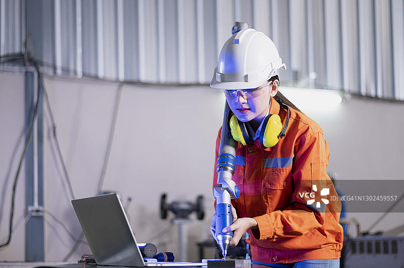 工程师使用平板电脑检测系统软件控制和检查智能汽车工业中手臂的焊接自动化图片素材