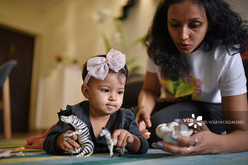年轻母亲和幼儿女儿一起玩玩具图片素材