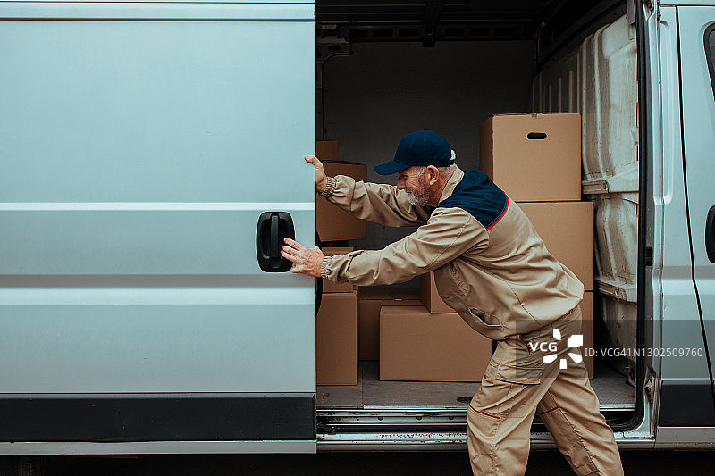 快递员将包裹装入货车图片素材