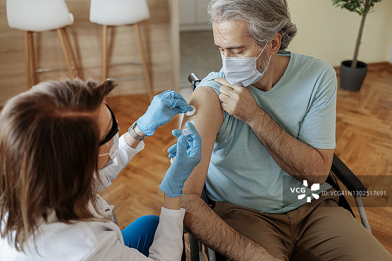 全科医生为残疾中年患者接种疫苗图片素材