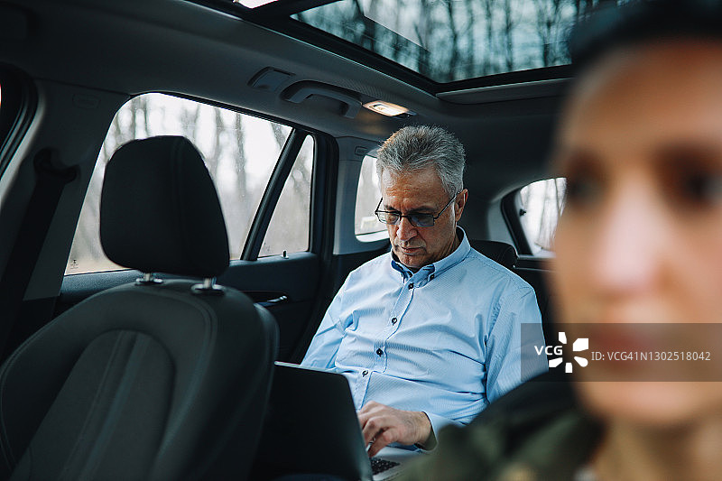 年长的男人在共享汽车上完成工作图片素材