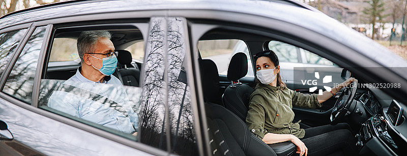 疫情期间与女司机一同乘坐共享汽车的年长男人图片素材