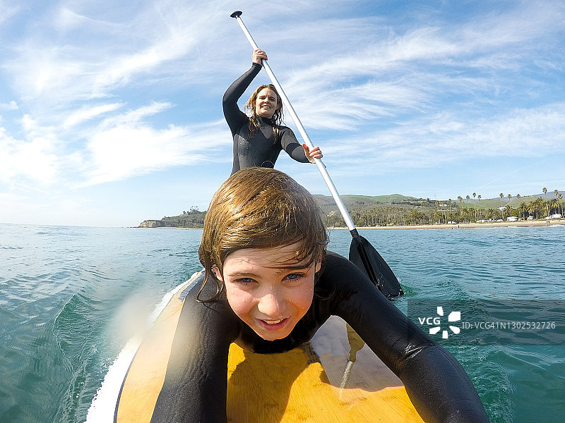 快乐地一起划桨板的母子图片素材