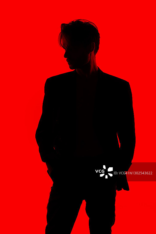 红色背景上身穿时尚夹克的年轻男子轮廓图片素材