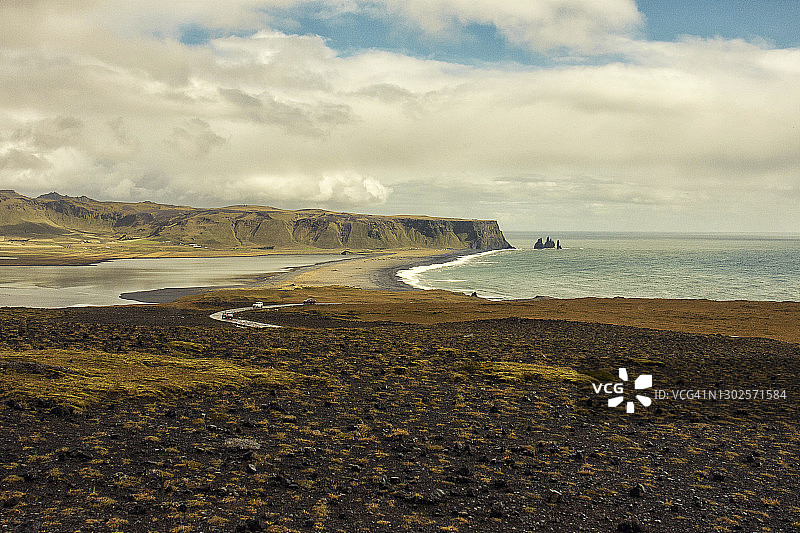 驾车行驶在冰岛南部的维克附近的Reynisdrangar悬崖，冰岛的黑沙滩图片素材