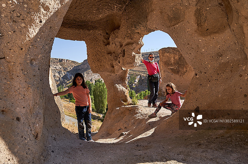 土耳其卡帕多奇亚，在恰乌辛岩石村的房屋石窗后的女孩图片素材