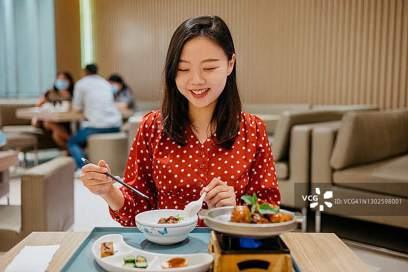 微笑亚洲女人品尝中国台湾三杯鸡图片素材