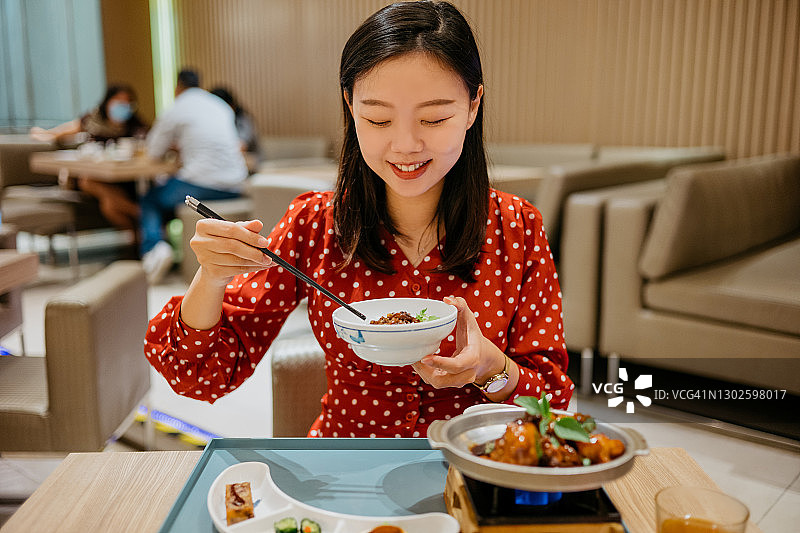 微笑亚洲女人品尝中国台湾三杯鸡图片素材