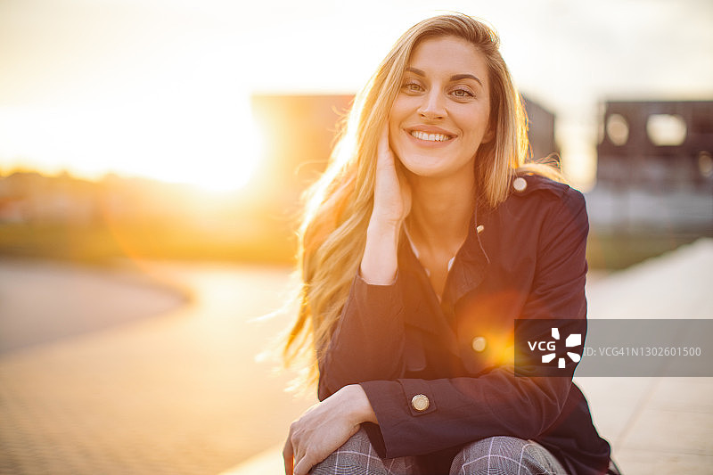 金色阳光下的美丽年轻女人图片素材