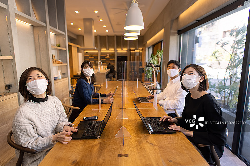 戴防护口罩在办公室开会的自由职业者图片素材