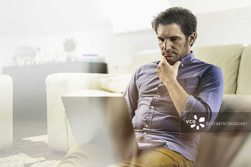 在家用笔记本电脑观看视频课程的白人男子图片素材