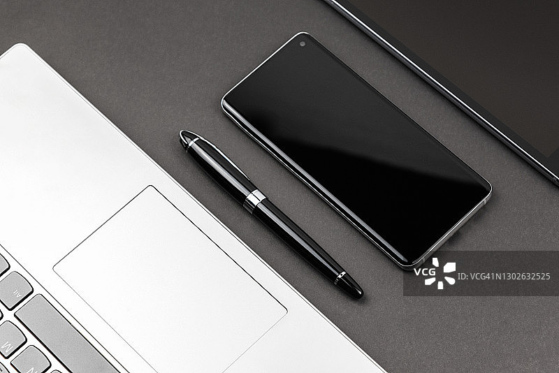 黑色背景上的智能手机和笔记本电脑图片素材