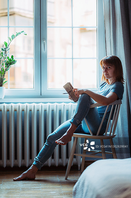 年轻女人在家中窗边放松身心图片素材