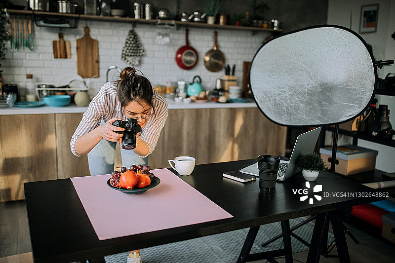 在工作室办公室工作的女美食摄影师图片素材