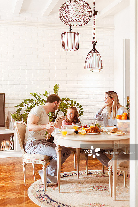 年轻家庭在餐桌上享用健康早餐图片素材