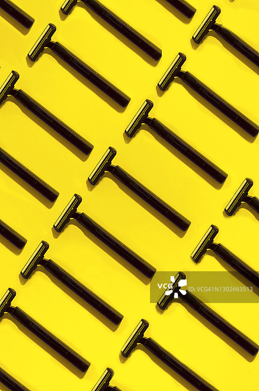 黄色背景上的重复黑色一次性剃须刀图片素材