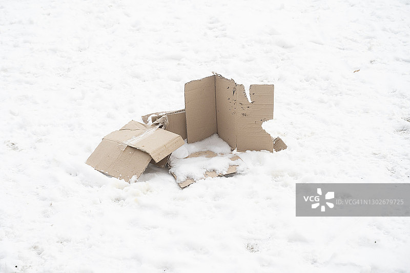 雪地上的废弃破损纸板箱图片素材