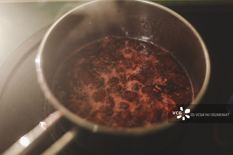 放在火上的平底锅。正在制作覆盆子酱。地点：西班牙安达卢西亚图片素材