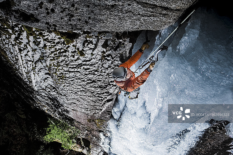 夜间俯视攀冰者悬挂在高处的巨大冰柱上图片素材