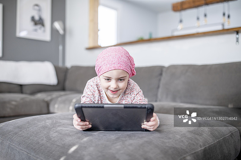 患癌症的年轻女孩用平板电脑看节目图片素材