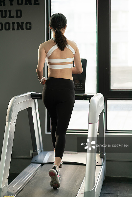 在中国台湾健身房使用跑步机的漂亮女孩图片素材