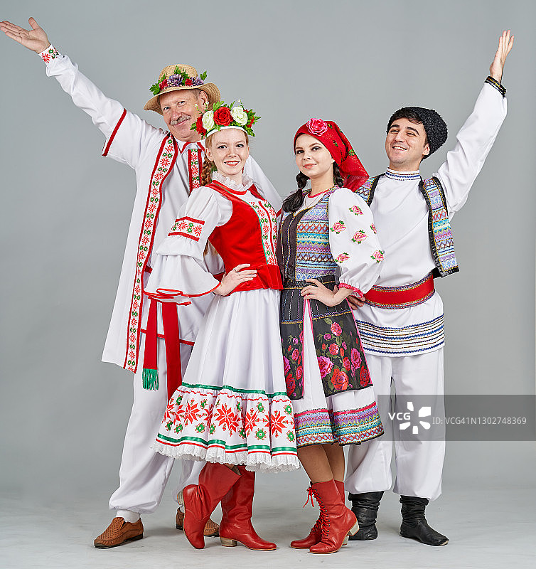 穿着白俄罗斯和摩尔多瓦民族服装的两对舞者，面带笑容地看着镜头图片素材