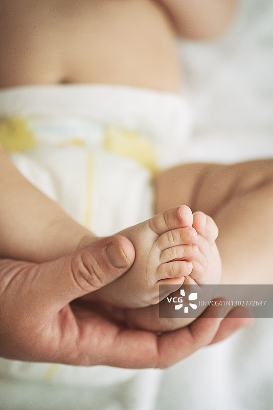母亲的手握着婴儿的脚图片素材