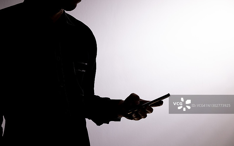 亚洲男人手持手机的轮廓图片素材