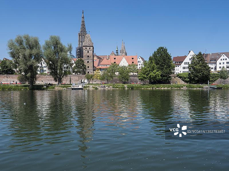 德国巴登-符腾堡州乌尔姆市多瑙河沿岸的乌尔姆大教堂和建筑群，水中倒影图片素材