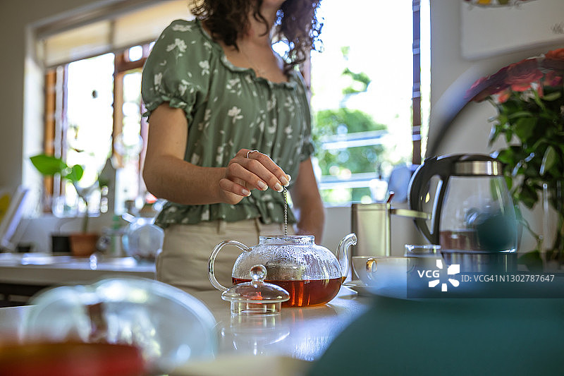 年轻女人准备一壶散装茶叶图片素材