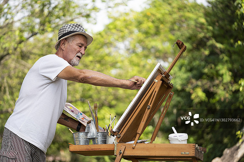 男人在帆布上绘画图片素材