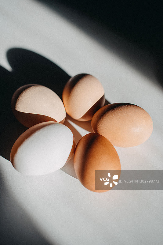 白色表面上不同颜色的5个鸡蛋图片素材