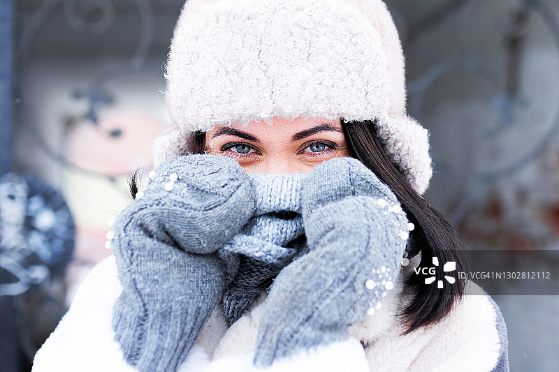 戴着帽子和手套的美丽女性面部特写，看着镜头图片素材