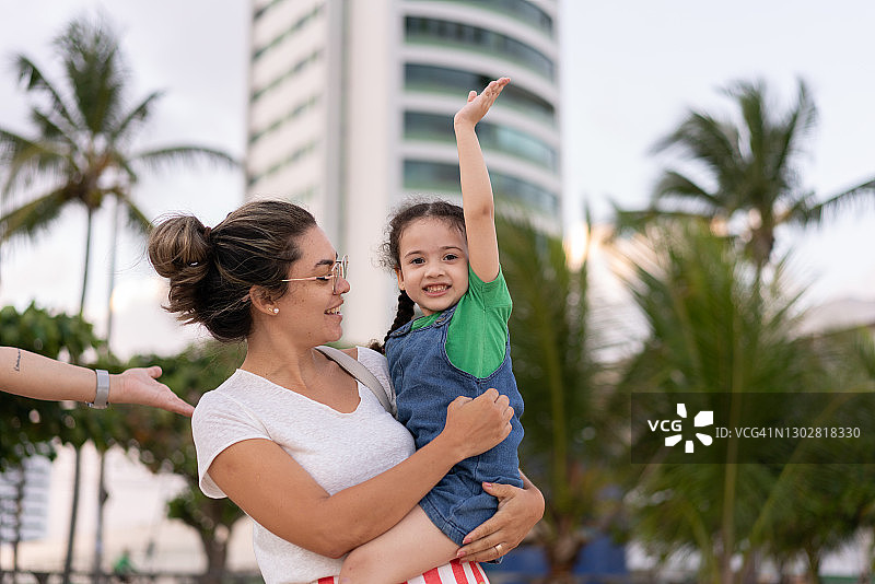 在阿姨怀里玩耍的小女孩图片素材