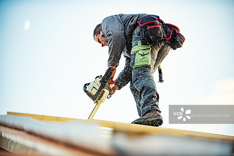 正在进行木屋顶施工的建筑工人图片素材