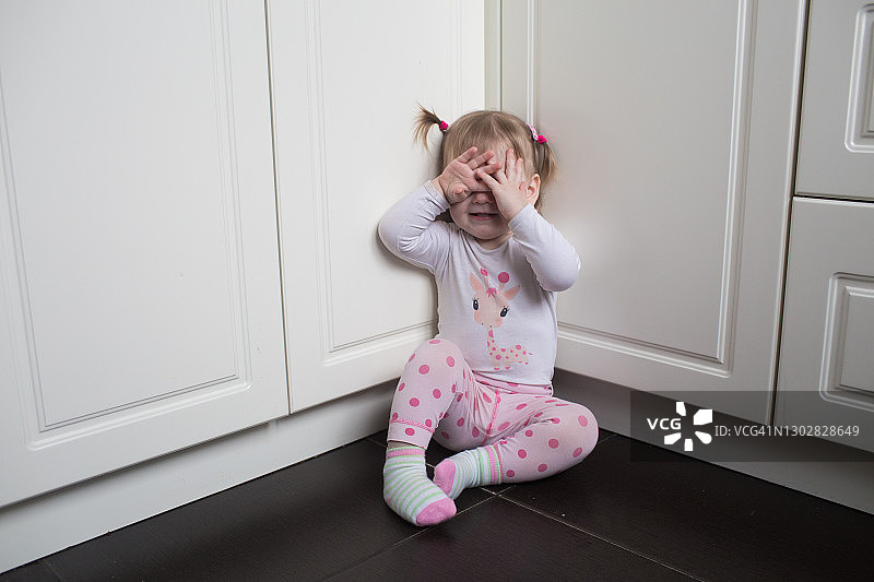 幼儿女孩用手捂住眼睛哭泣图片素材