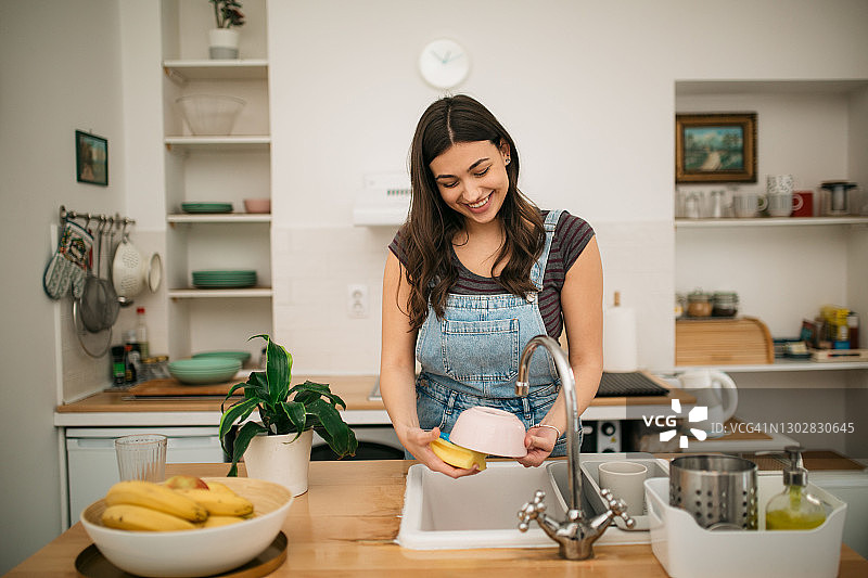 快乐的白人女人在家洗碗图片素材