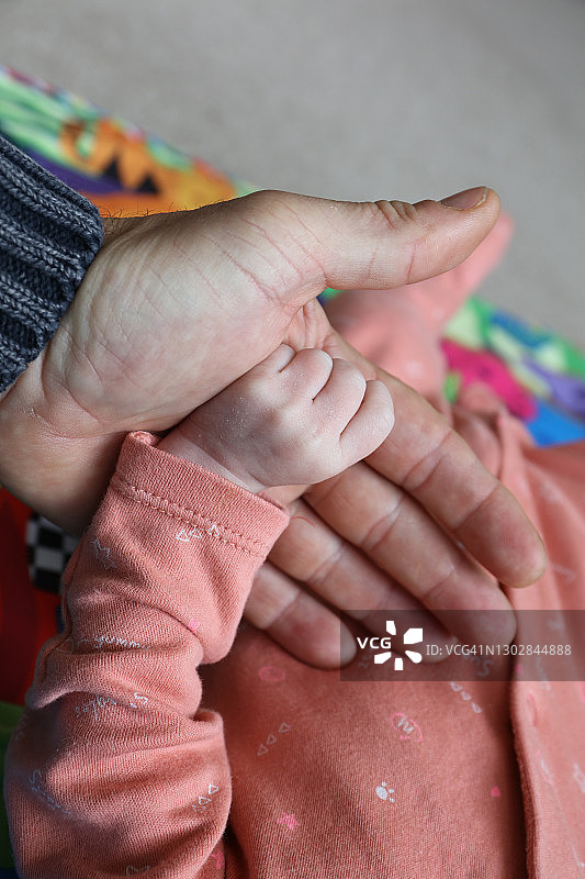小宝宝的手握着父亲的手指，代表父子之爱、亲密和帮助图片素材