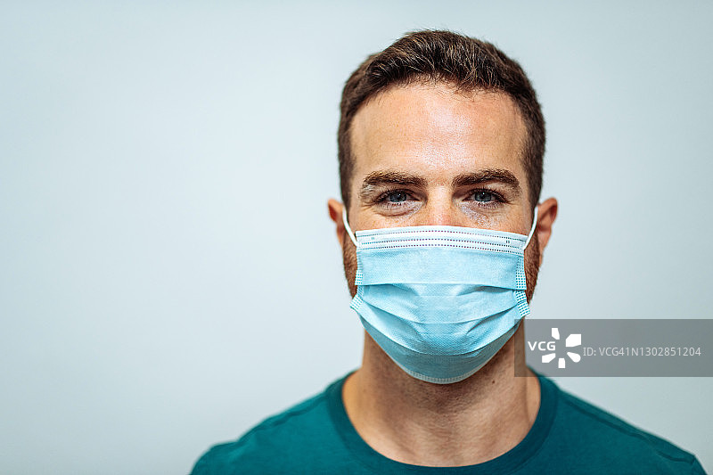 戴口罩的快乐年轻男子肖像图片素材