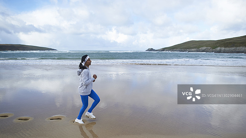 在海滩上奔跑的亚洲女人图片素材