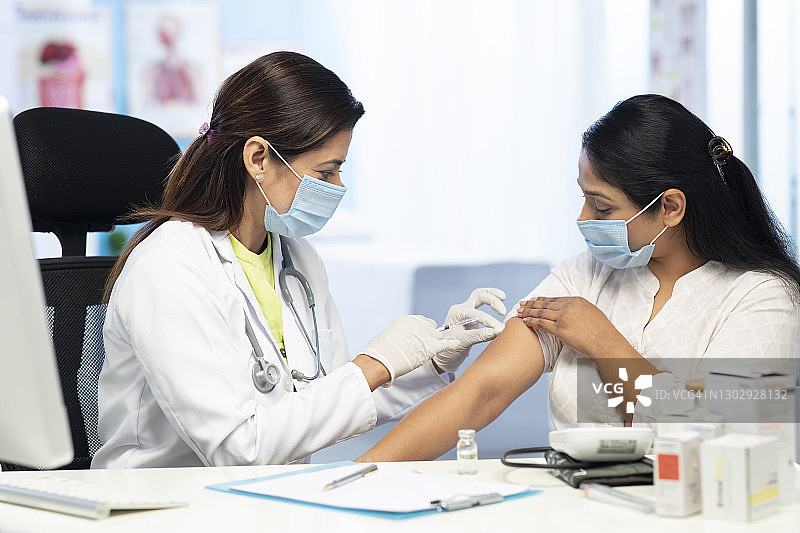 医生为女病人注射疫苗或药物，素材照片图片素材