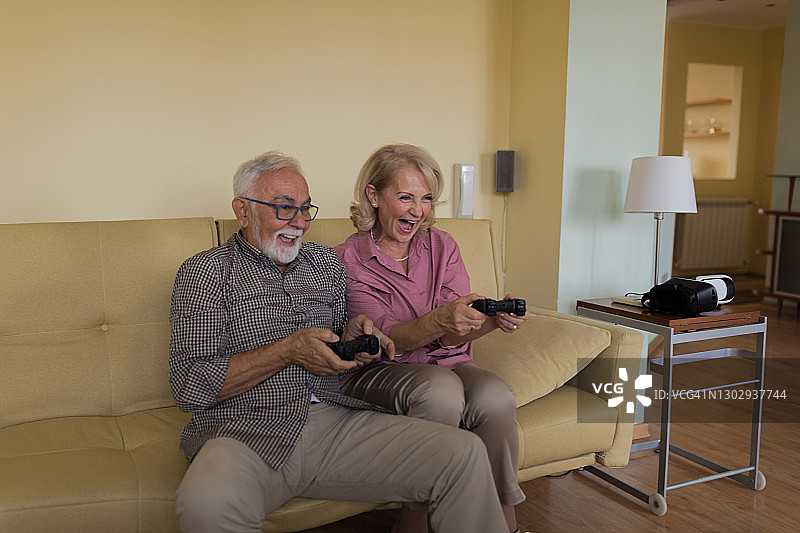 重返童年：退休人员玩电子游戏，乐享美好时光图片素材