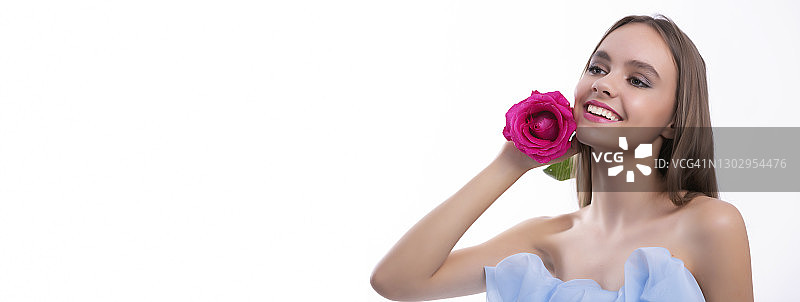 手持粉色玫瑰的美丽年轻女人图片素材