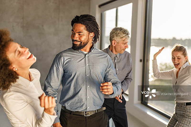 快乐的商务团队在办公室聚会上跳舞。图片素材