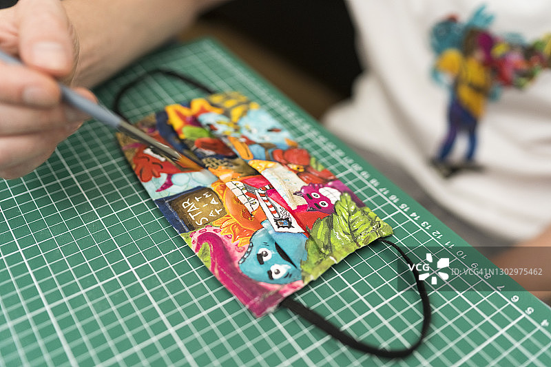 漫画家在家中在口罩上绘画涂鸦图片素材