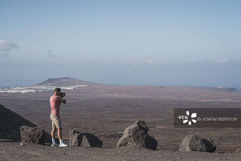 在西班牙兰萨罗特岛费梅斯观景点拍照的年轻男游客图片素材