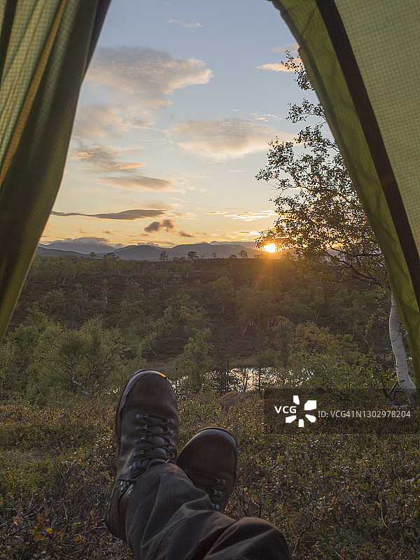 瑞典，森林日落时分，帐篷里的中年男徒步旅行者图片素材