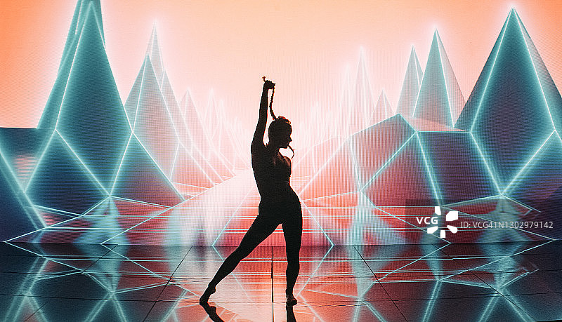 女现代舞者在紫色山脉和霓虹灯背景下表演图片素材